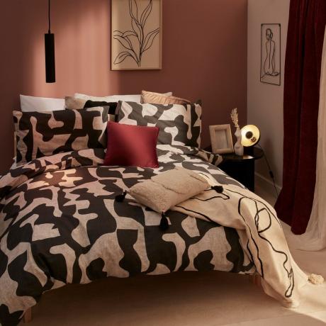 Dormitorio rosa con ropa de cama en blanco y negro