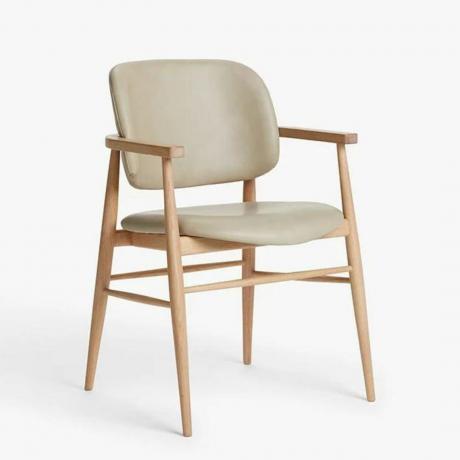 Μια κρεμ δερμάτινη καρέκλα με ξύλινα πόδια και μπράτσα
