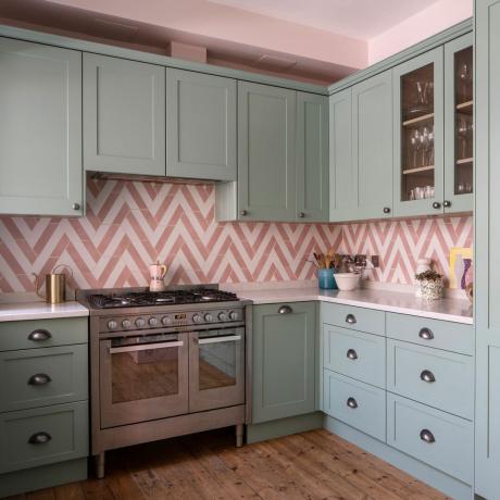 Grønne kjøkkenenheter med hvite og rosa fliser i sikk-sakk-design