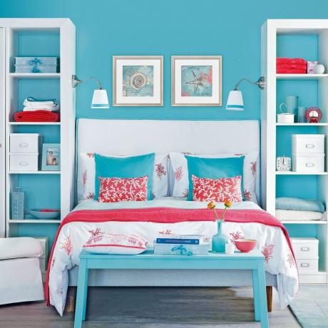 kamar tidur dengan dinding biru dan unit rak penyimpanan putih di kedua sisinya