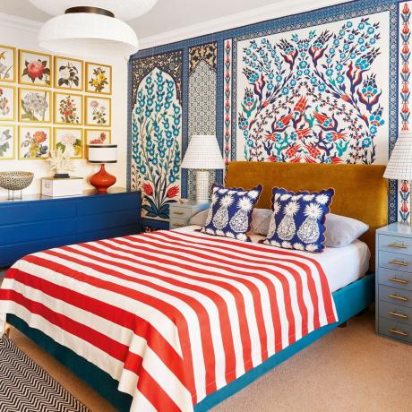 Pagrindinis miegamasis su spalvingais raštuotais tapetais ir raudonai baltai dryžuota lovatiese