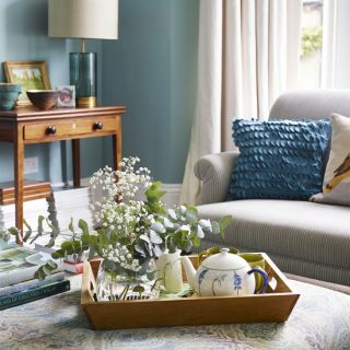 Sala de estar tradicional con paredes azules y bandeja de té