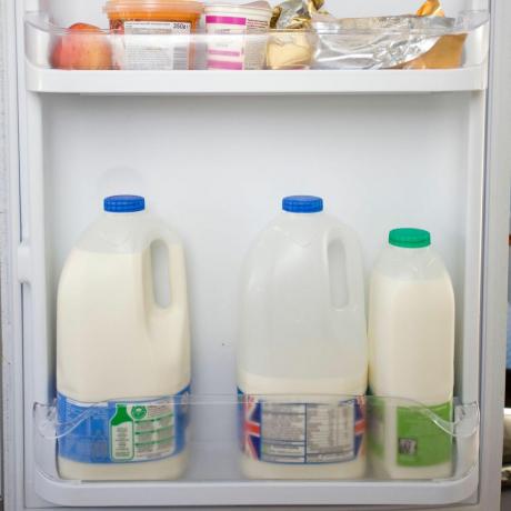 atveriet ledusskapja durvis ar piena pudelēm