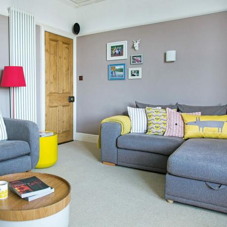 Pelēka dzīvojamā istaba ar moderniem dzelteniem aksesuāriem