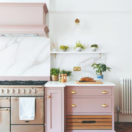 Blekrosa köksskåp i vitt marmorkök