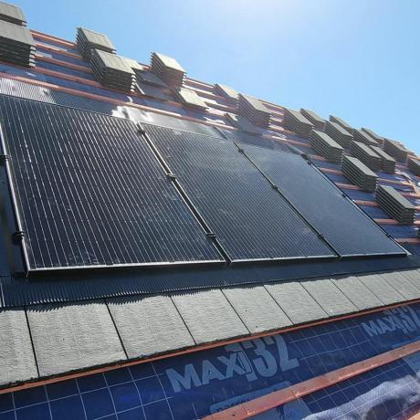 Exeo-Energy-solar-panel-being-mounted-on-mitched-roof. إكسيو-إنيرجي-سولار-بوردز-يجري-تركيب-على-سقف-مارج