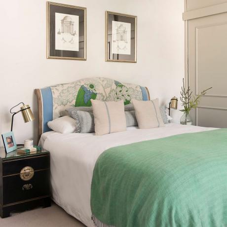 덮개를 씌운 침대와 녹색 담요가 있는 침실