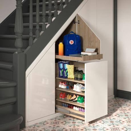 un cajón de almacenamiento extraíble oculto debajo de las escaleras, para guardar los zapatos de los niños