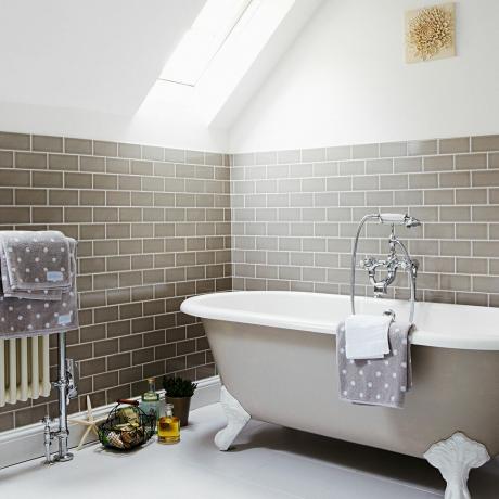 Hvidt og gråt badeværelse med grå metrofliser og gråt fritstående badekar