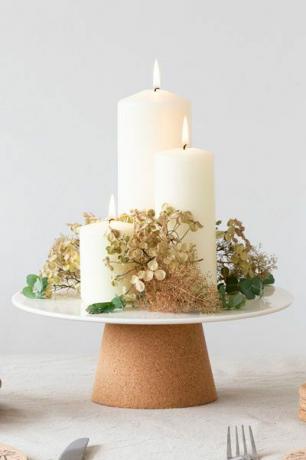 tårtfat med keramikskiva och korkbotten på ett bord med ljus och blommor