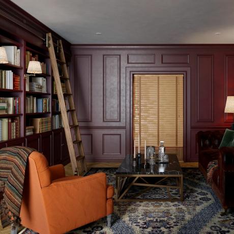Yerleşik kitap rafları, merdiven ve iki kanepe içeren bir kütüphane odası