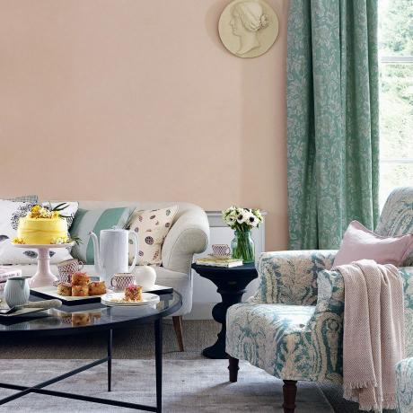 Sala de estar en colores pastel con sofá y sillón tapizados