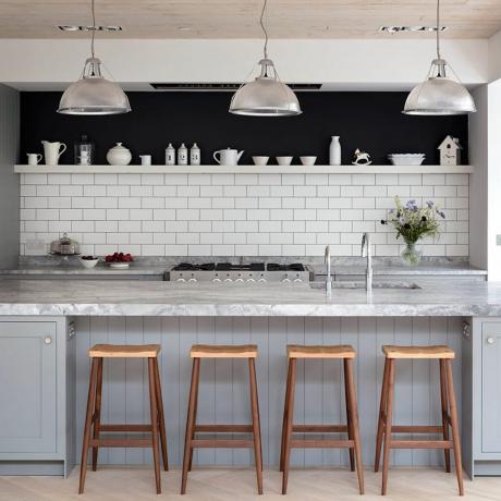 pilka virtuvė su baltomis metro plytelėmis ir sala su marmuru
