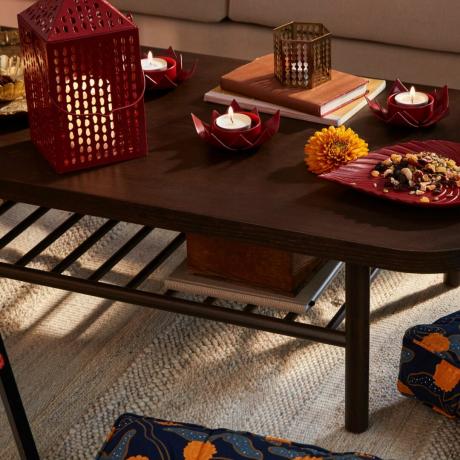 Aksesori IKEA Aromatisk tersebar di meja makan kayu berwarna gelap, di atas permadani krem
