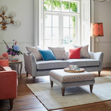 Grå sofa med blomstermønstrede sider i stuen