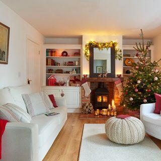 Sala de estar festiva neutra con gran chimenea de estilo rústico