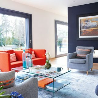 그림창과 오렌지색 소파가 있는 세련되고 현대적인 거실