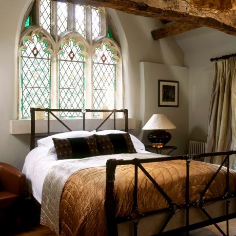 Sovrum järn säng välvda gotiska målat glas fönster