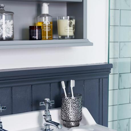 Cambio de imagen del baño con azulejos de piso de declaración de baño con tapa enrollable y paneles de madera en la parte superior 