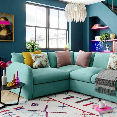 Žalsvos spalvos kampinė sofa ryškiaspalvėje svetainėje