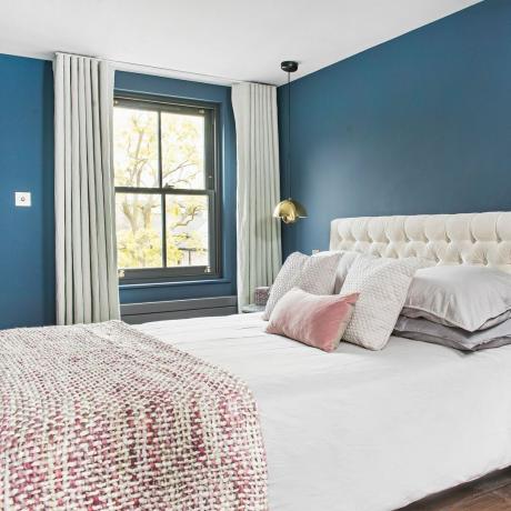 Blauwe slaapkamer met zwart geschilderde schuiframen