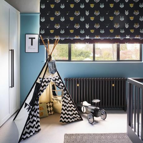 dětský pokoj s modrými stěnami se vzorem rolety a teepee