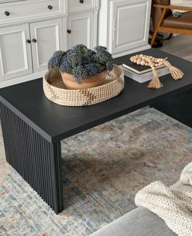 アンティーク スタイルの敷物の上に黒いコーヒー テーブル