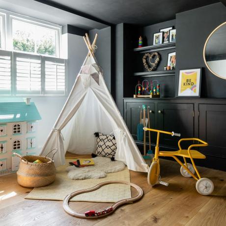 Črna fantovska igralna soba s tipi šotorom, belimi polkni, vgrajenimi policami