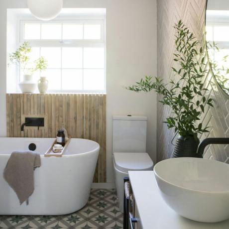 창문이 있는 욕실, 흰색 목욕 문지름, 나무 스플래쉬백 및 검은색 수도꼭지