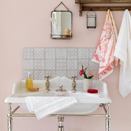 раковина для ванной комнаты с серой плиточной спинкой и бледно-розовыми стенами
