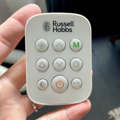 Russell Hobbs RHPAC11001 kannettavan ilmastointilaitteen kaukosäädin, jota pidetään naisen kädessä