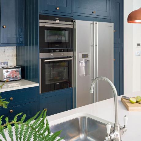 marinblått kök med stort kylskåp i amerikansk stil och ö