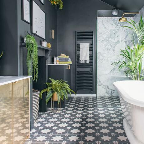 tumma kylpyhuone, jossa kuviolliset lattialaatat ja rullakylpyamme