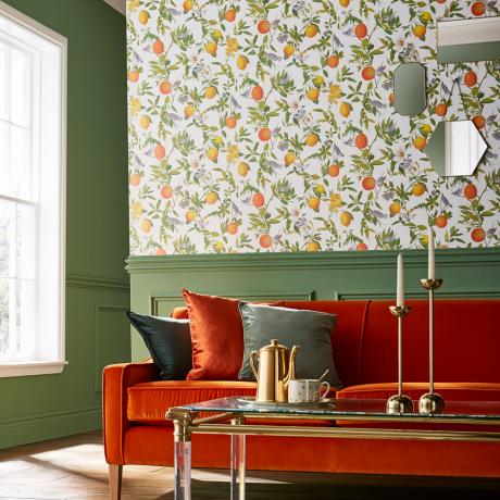en brent oransje sofa med grønne veggpaneler og Amalfi Fresco tapet av Graham og Brown
