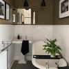 Nespalvotas vonios kambario pertvarkymas su juoda ritinine vonia ir išskirtinėmis grindų plytelėmis
