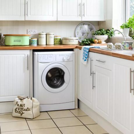 सफेद वॉशिंग मशीन के साथ सफेद रसोई
