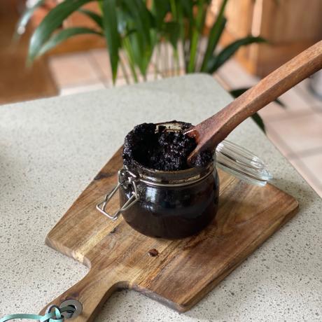 Tarro de exfoliante de café casero con cuchara de madera