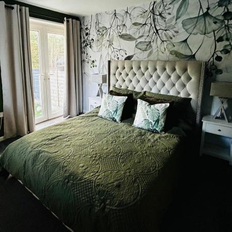zelená ložnice s květinovou tapetou