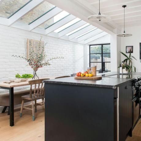 Kjøkkenside returtilbygg med hvitmalte murvegger og glasstak