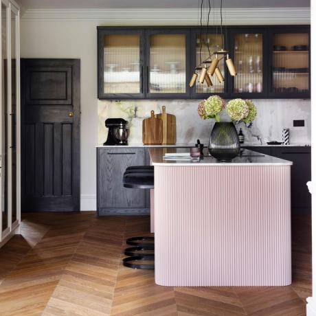 cozinha com balcão rosa e armários bacl com portas de vidro palheta