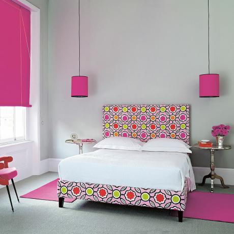 Dormitorio gris con acentos de color rosa fuerte cama rosa tapizada con dibujos