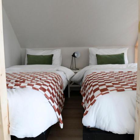 quarto com duas camas de solteiro e manta xadrez