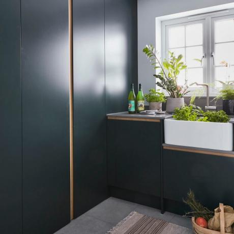 идеи за цвят на мокро помещение, тъмно синьо мокро помещение с елегантни модерни врати и шкафове, мивка Belfast, растения, килим, сив под с плочки