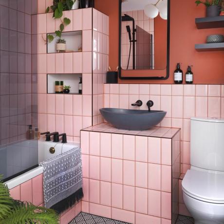 Salle de bain carrelée rose avec plantes