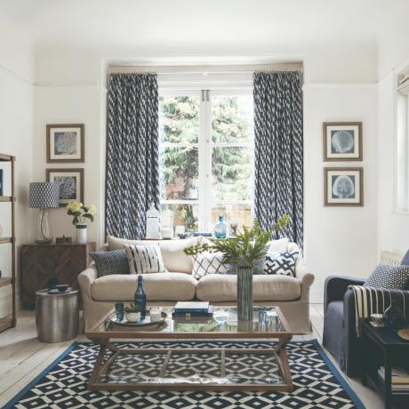 En stue med glasdøre og matchende mønstrede gardiner og tæppe