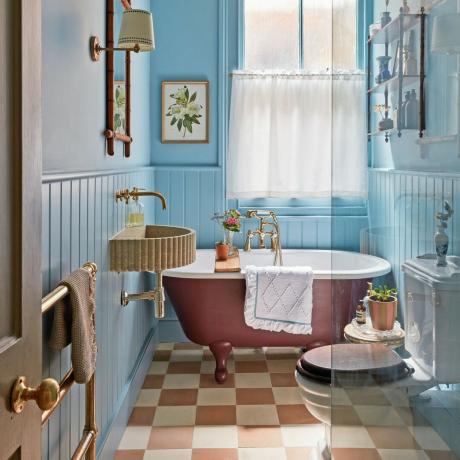 Cuarto de baño pintado de azul con bañera pintada de rosa