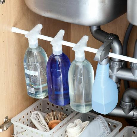 Пляшки з миючими засобами під раковиною
