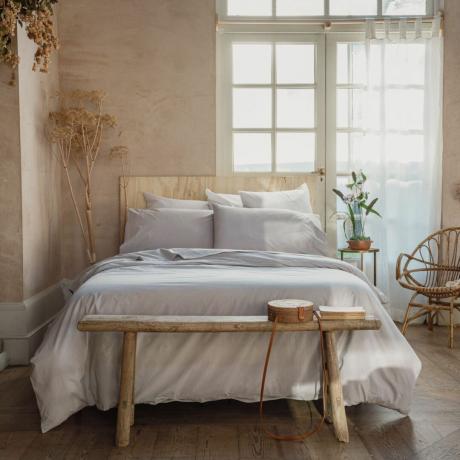 Мека неутрална спаваћа соба са белим брачним креветом