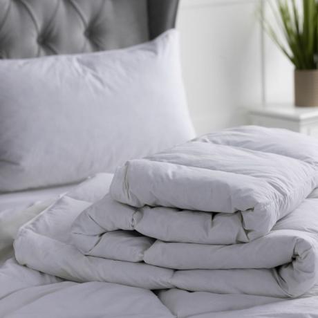 Weiße Bettdecke auf dem Bett zusammengefaltet