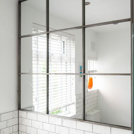 Balts vannas istabas pārveidojums ar oranžiem dvieļiem
